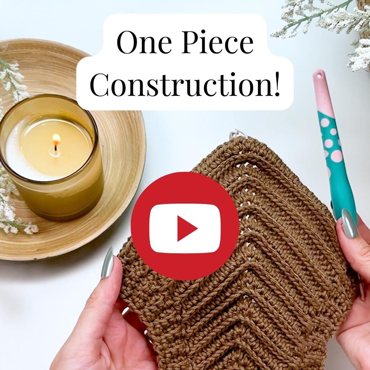 Person holding a crochet project with a teal and pink crochet hook, next to a lit candle. Text on image reads, "One Piece Construction!" with a YouTube logo.