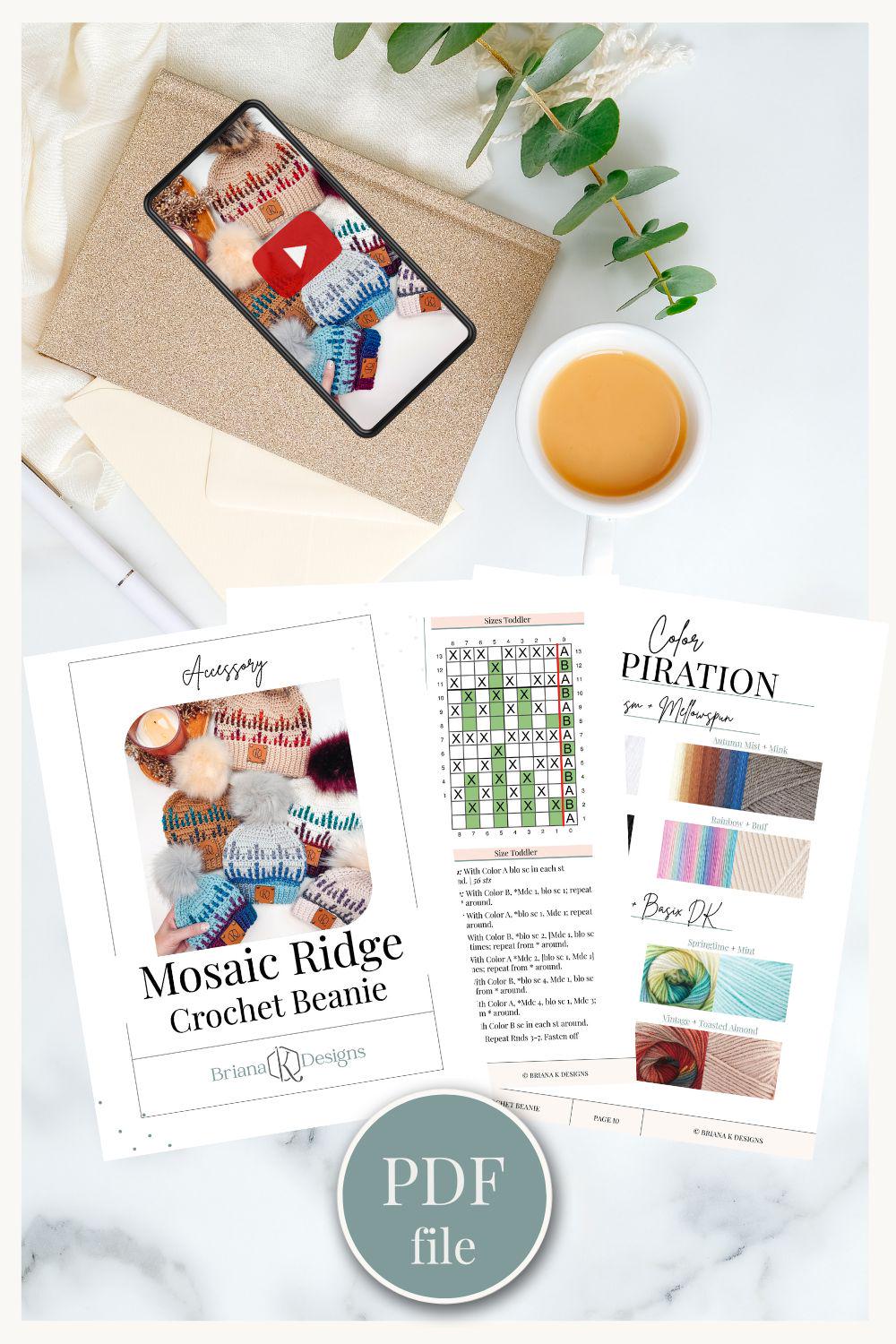 A crochet beanie pattern PDF is displayed alongside a smartphone showing a video, a cup of coffee, and a plant on a table, making it an ideal setting for crafting handmade gifts.