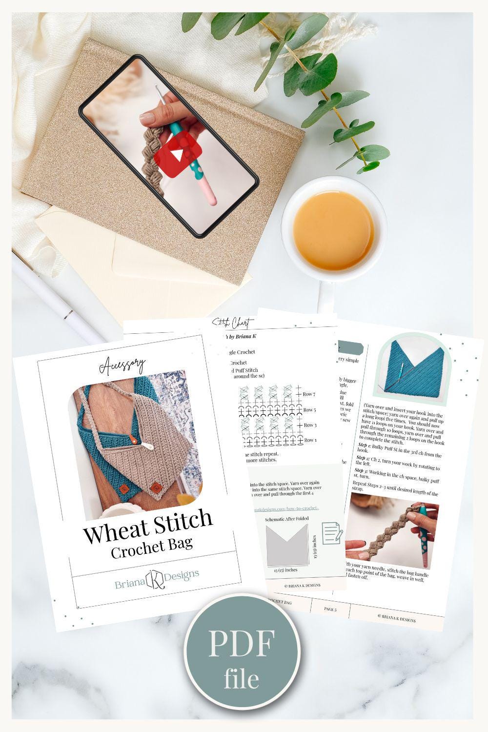 Flat lay of a crochet bag pattern PDF, a phone showing a crochet tutorial, a cup of coffee, envelope, and greenery on a white surface—perfect inspiration for crafting a handmade gift.