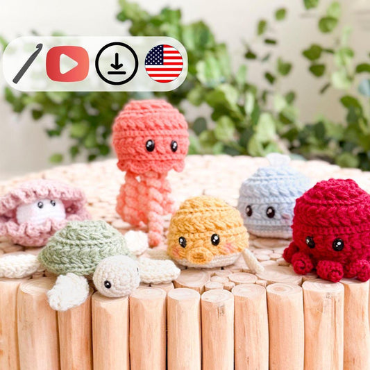 A crocheted purple jellyfish with large cartoon eyes on a stick makes a charming handmade gift, with a smaller image of a gray jellyfish and crochet tutorial icons on the left.