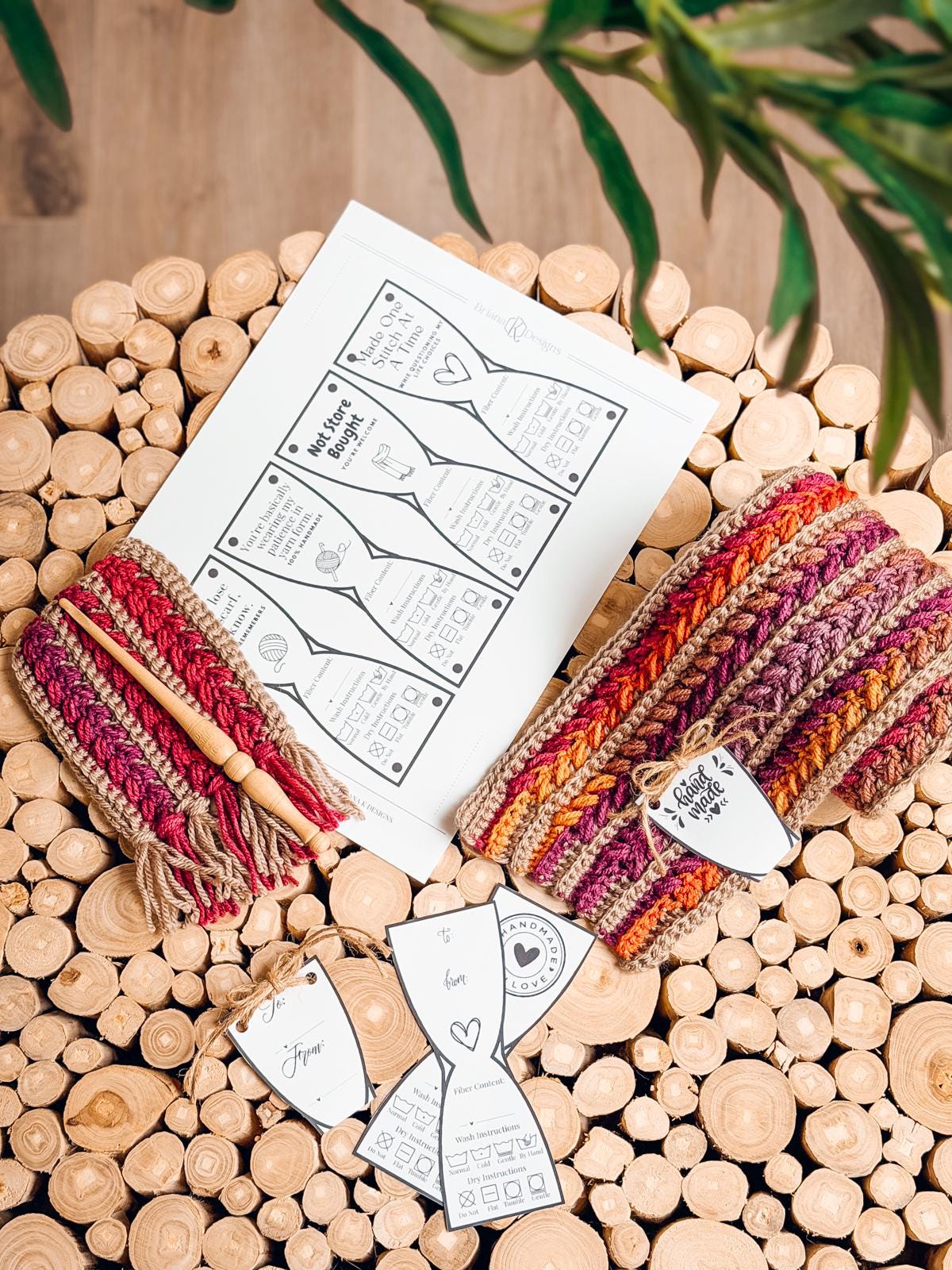 Crocheted items with vibrant multicolored yarn, wooden crochet hooks, printed instruction sheets, and handmade tags are artfully arranged on a surface crafted from stacked wooden pieces.