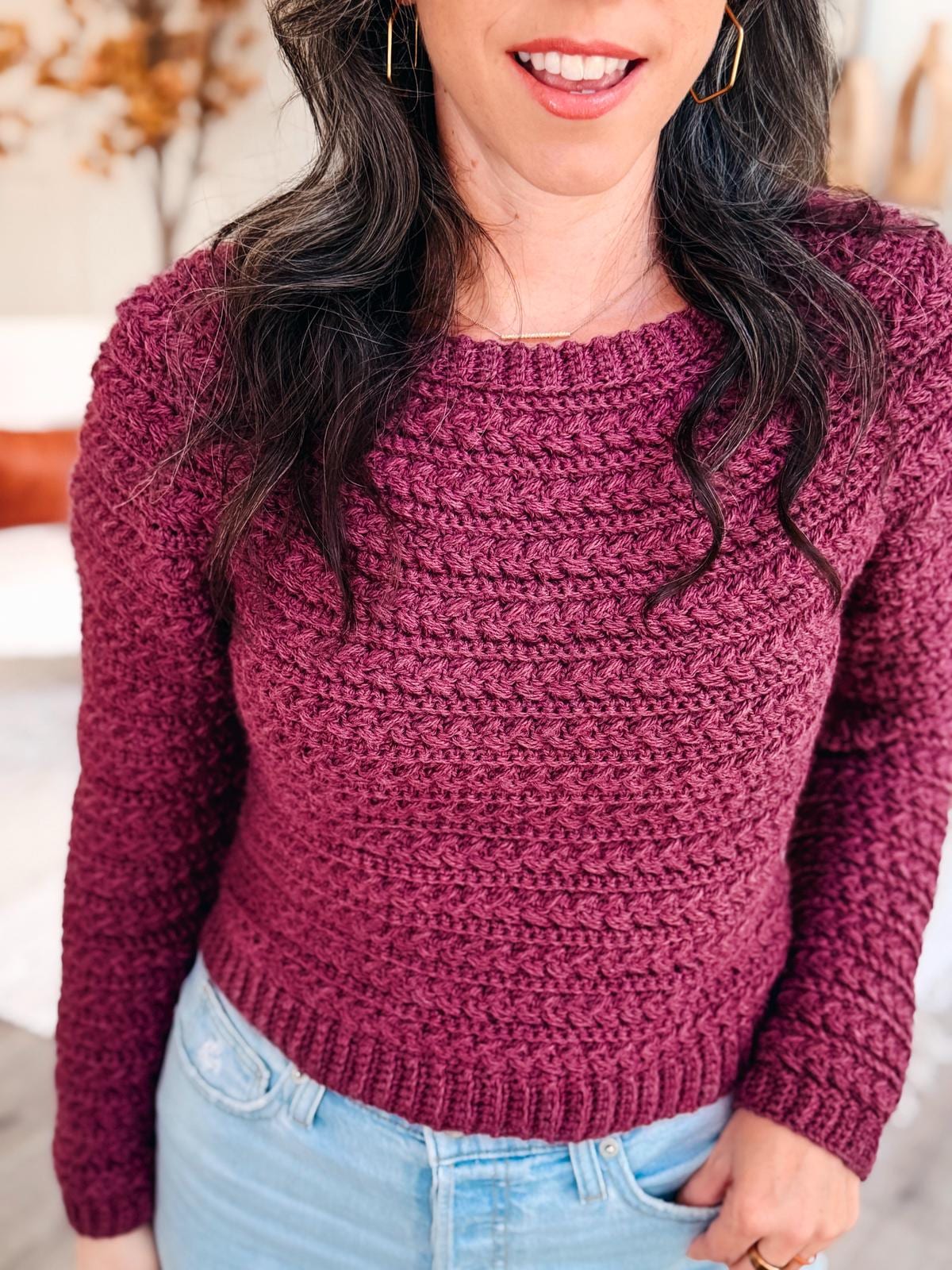 Model showcases the Wheat Stitch Crochet Sweater in soft variegated yarn; the crochet pattern includes 9 inclusive sizes, video tutorial, and guided sleeve decreases for easy customization.