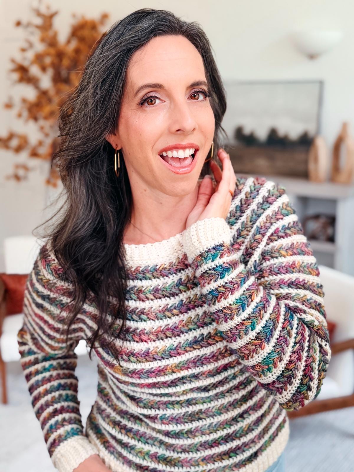 Smiling woman models a multicolored crochet Wheat Stitch Sweater; on-screen text promotes 9 size options and guided sleeve shaping, making this crochet pattern a great project for gifting or personal wear.