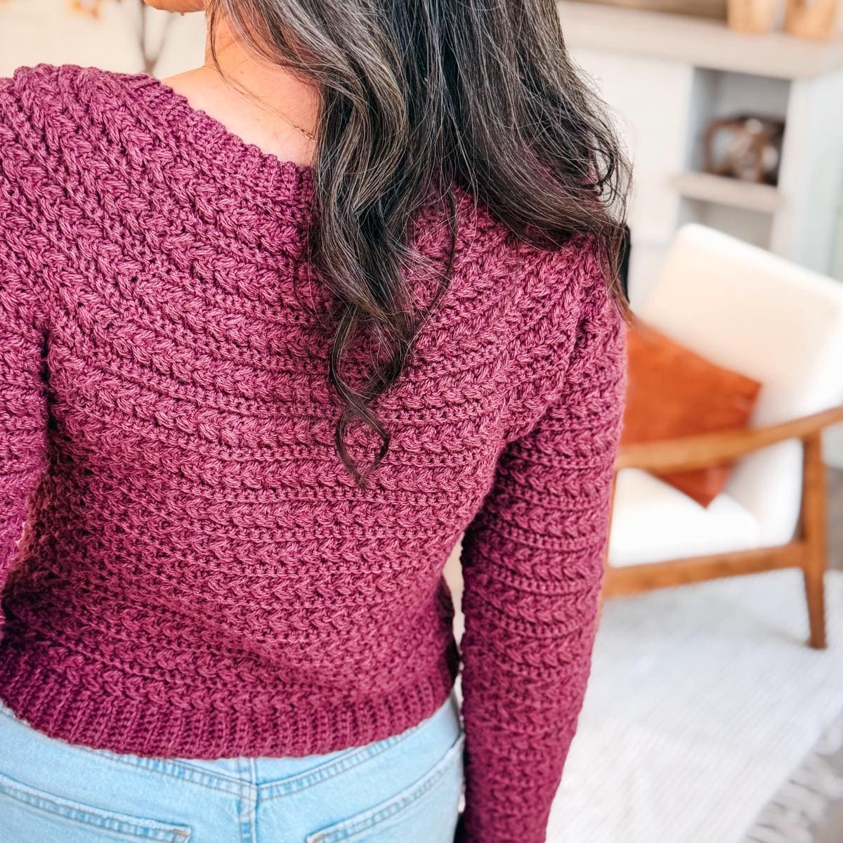 Woman wearing a multicolored Wheat Stitch Crochet Sweater smiles outdoors; this top-down no-sew crochet pattern includes 9 sizes and step-by-step sleeve shaping for a perfect handmade fit.