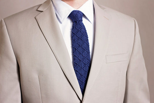 Bradford Knit Tie crochet pattern: navy crochet tie with diagonal textured stripes worn with a white shirt and light beige suit jacket