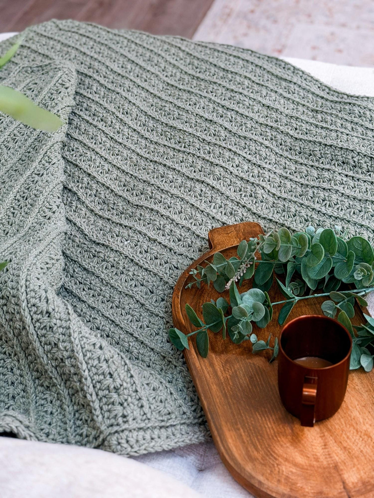 Close up of the Petal Loop Stitch texture on a sage green crochet blanket