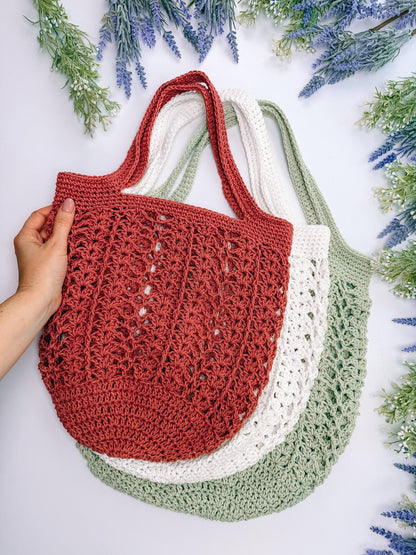 Terracotta Willow Mesh crochet market bag held up with cream and sage bags behind